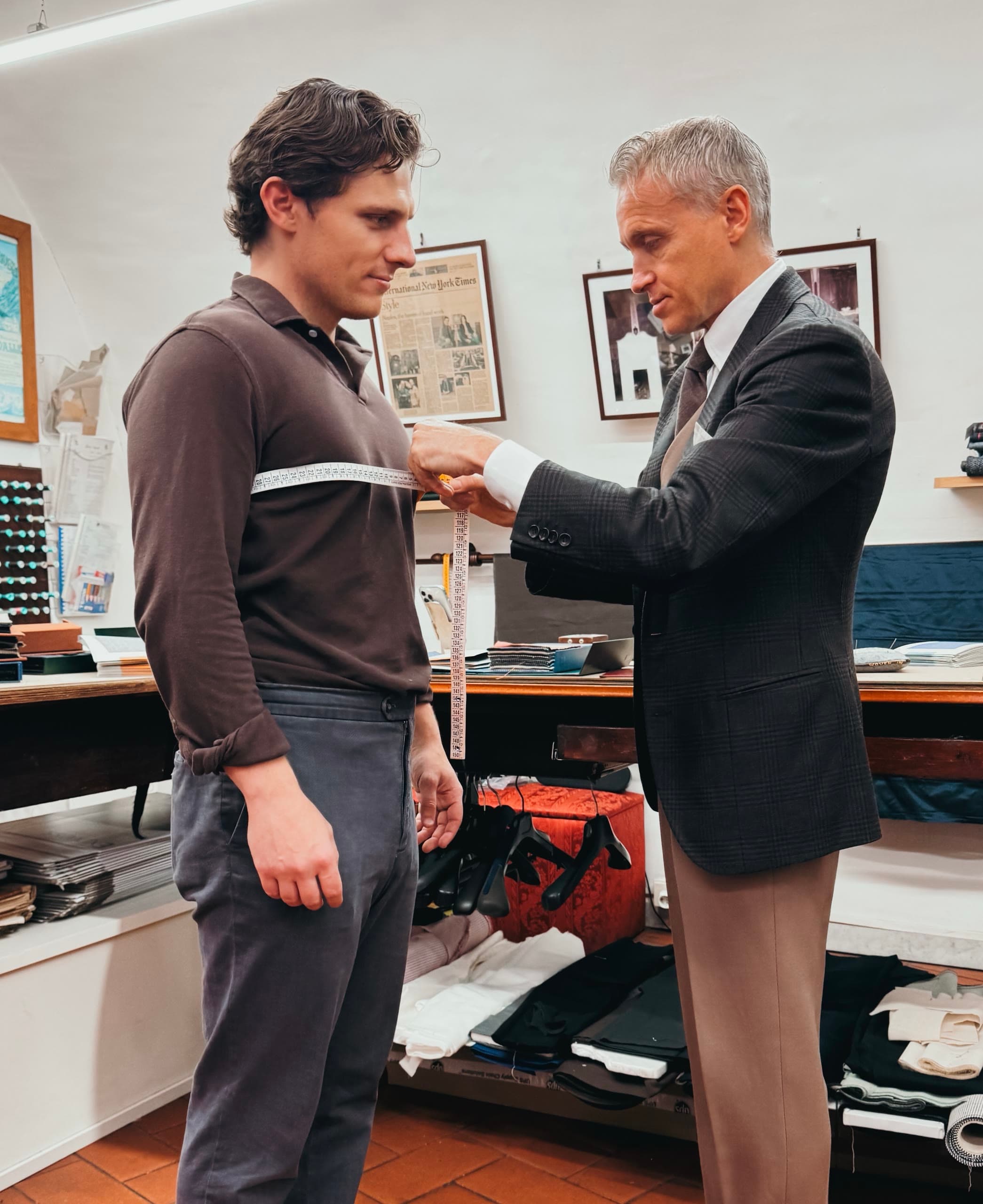 A tailor wraps a measuring tape around a client’s chest in the Sartoria Tofani atelier.